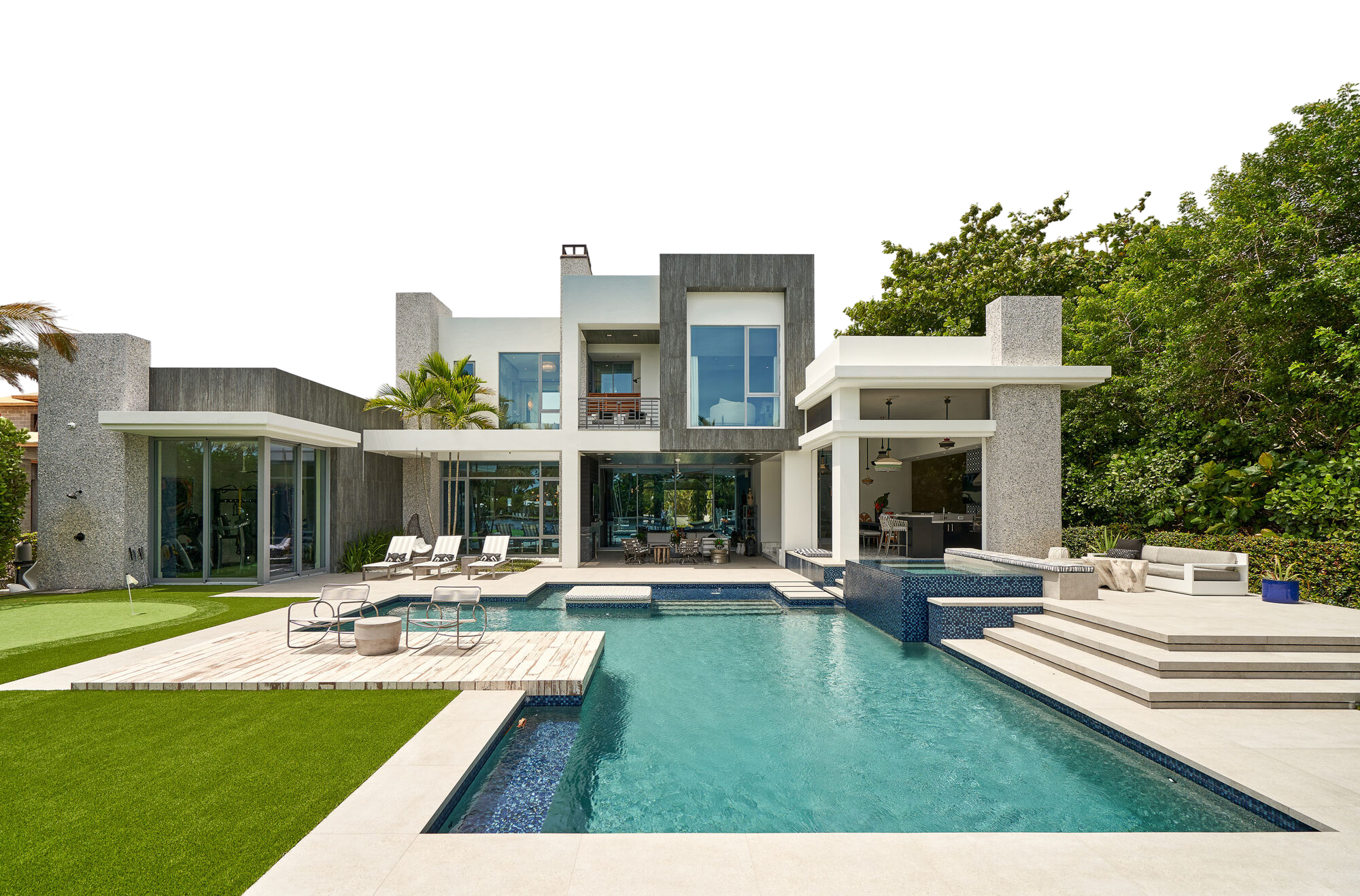 Contemporary South Florida residence with a pool terrace and putting green