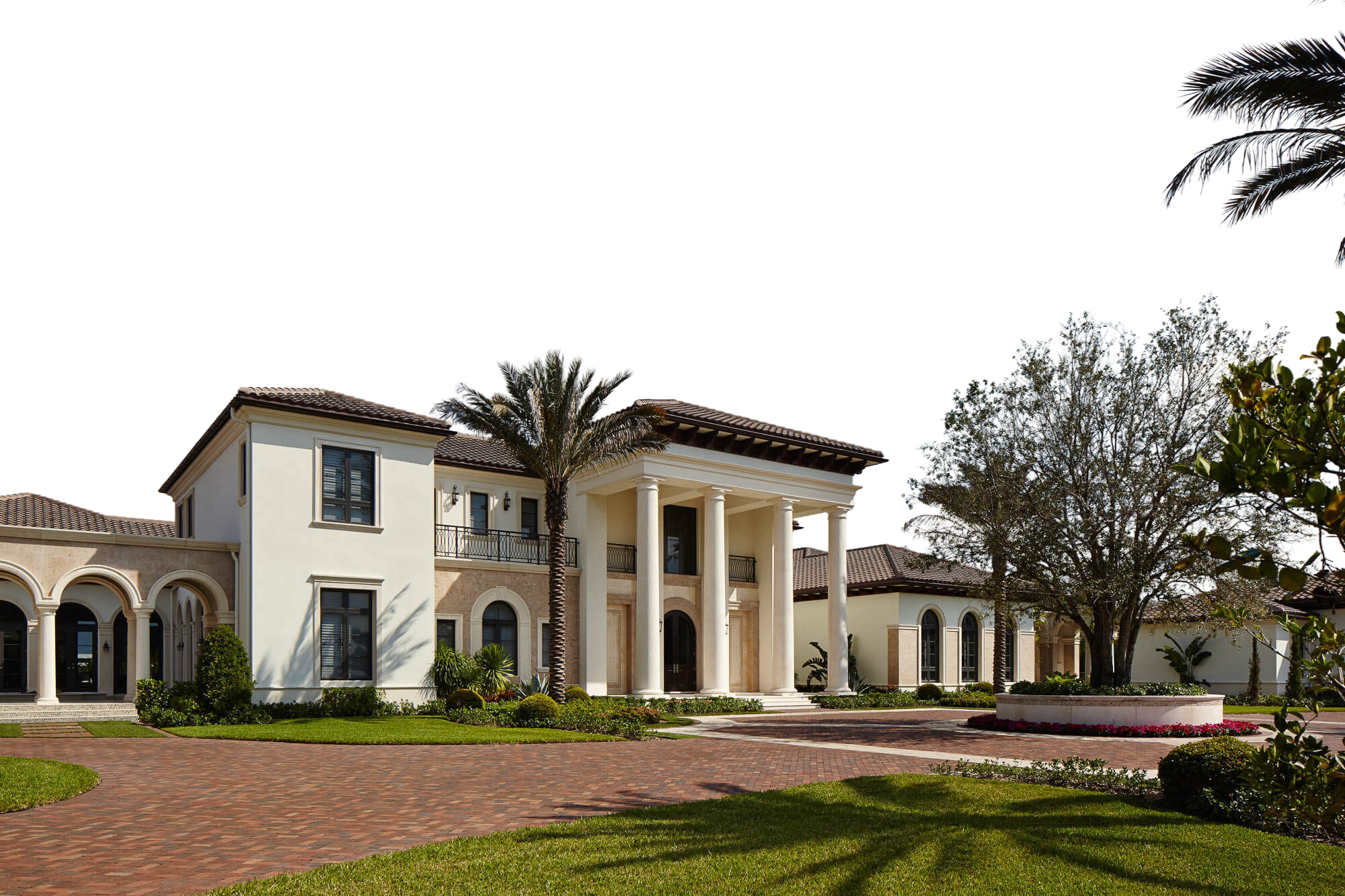 Mediterranean estate with a columned entrance and a brick motor court
